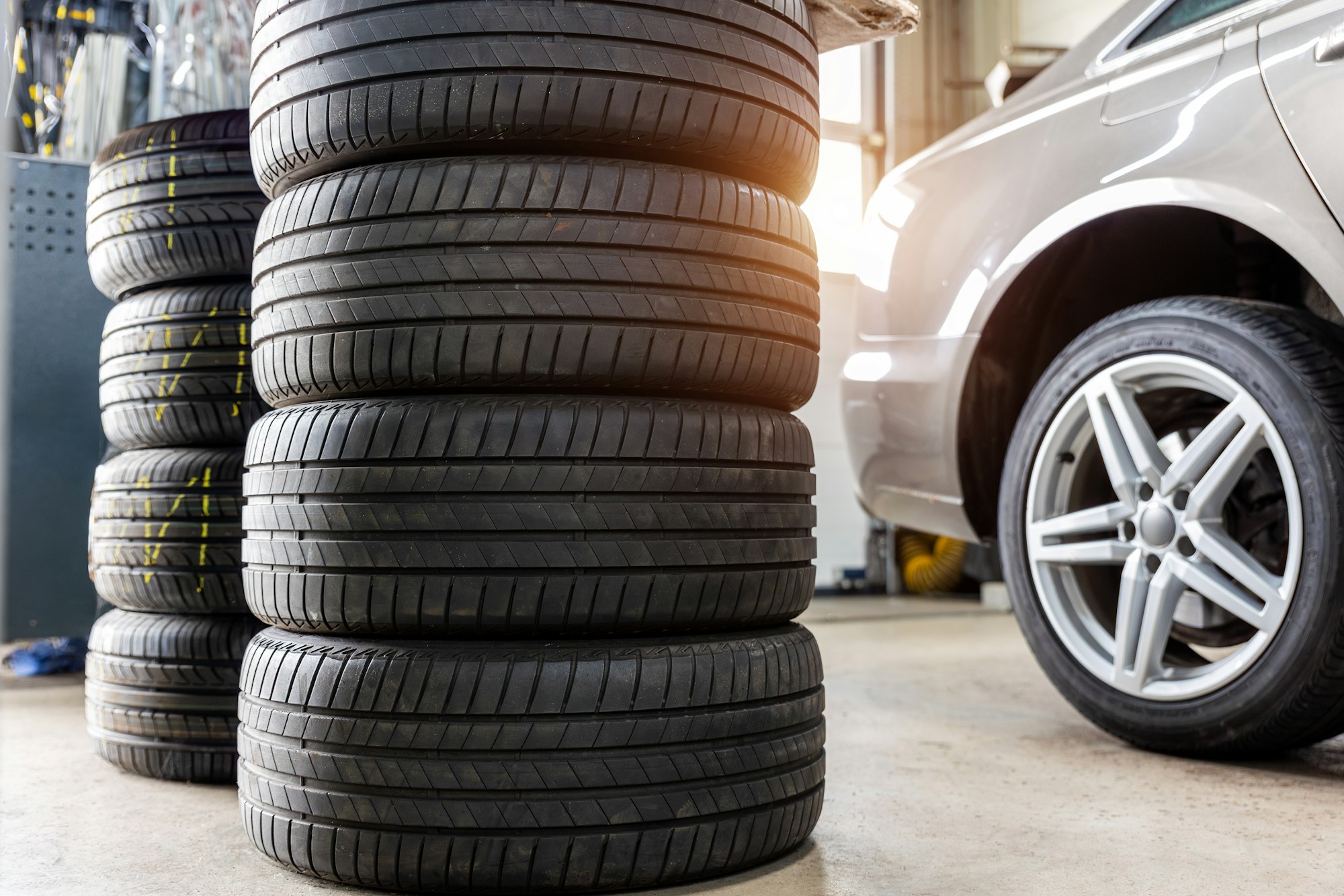 Car wheel repair with two auto lift back view. Seasonal winter tyre change at workshop. Vehicle tire